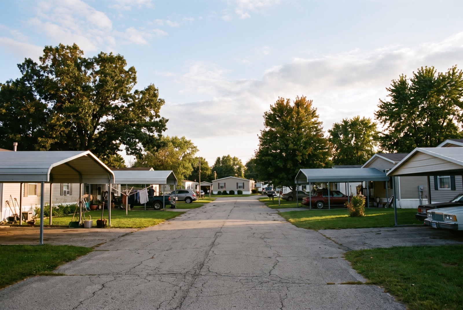 A street of manufactured homes with carports and small lawns